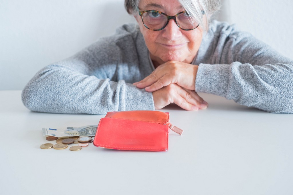 Earn her living. Wallet without money. An old woman counting money. An old woman counting Euros.